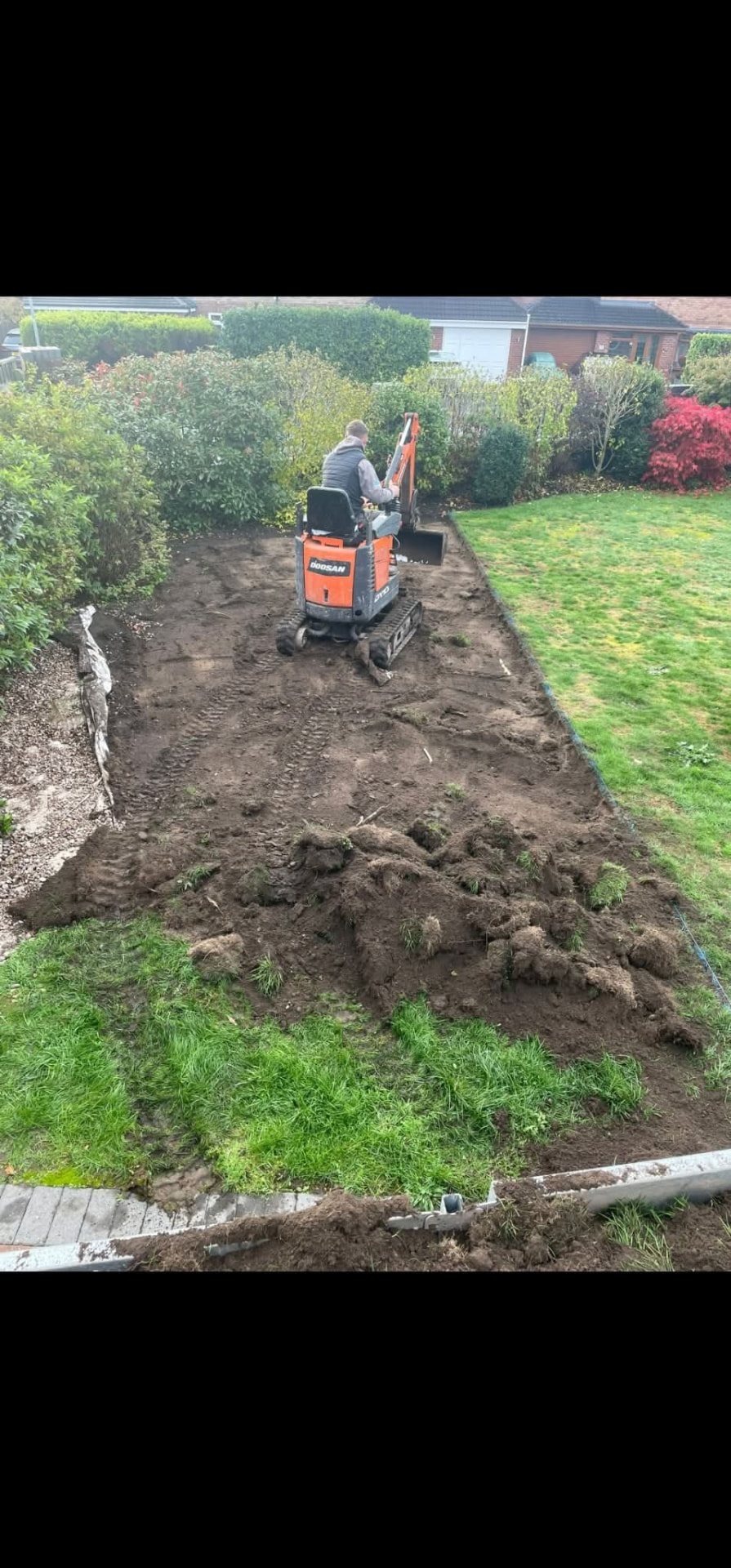 Garden excavation and ground preparation using a tracked excavator