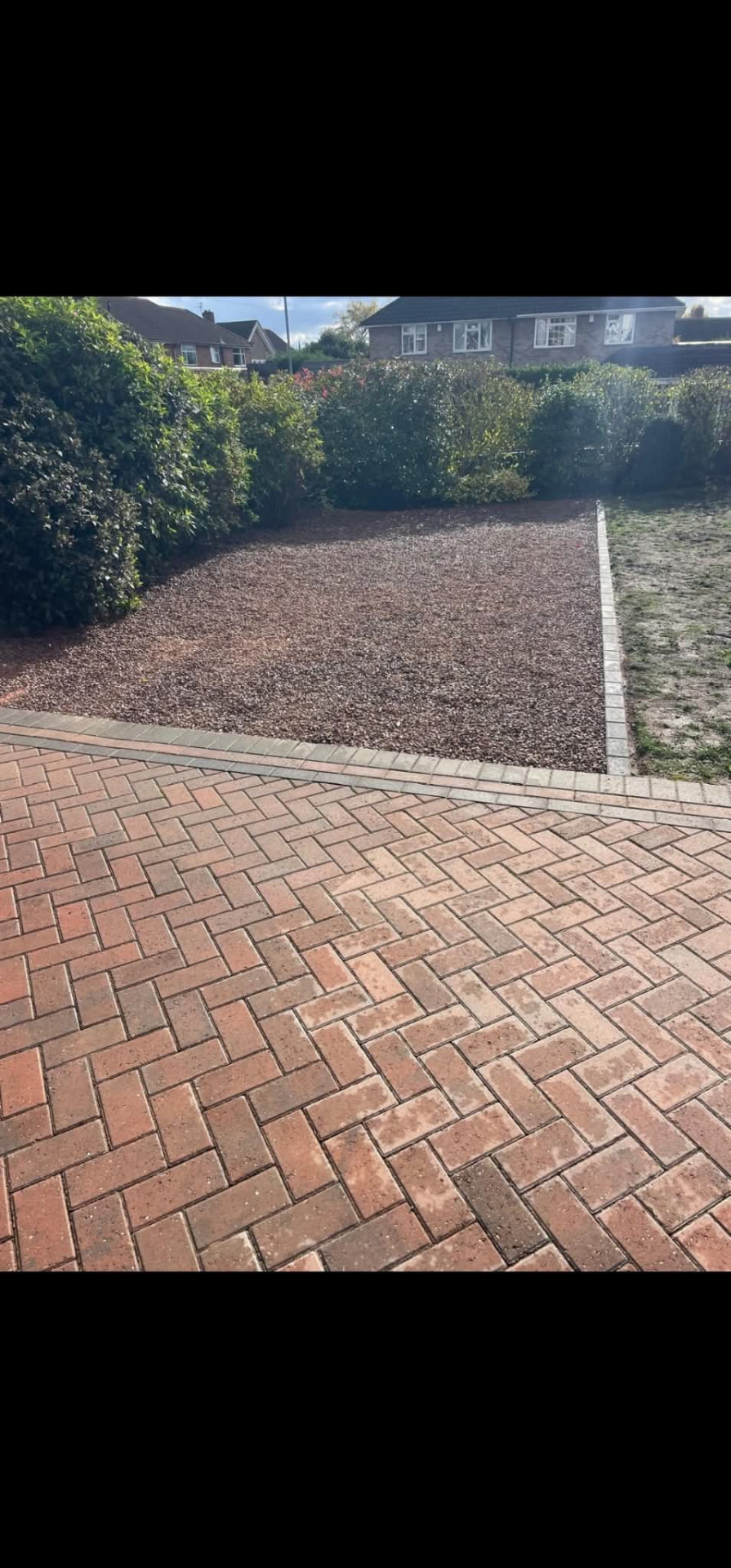 Finished decorative gravel garden area beside block paving